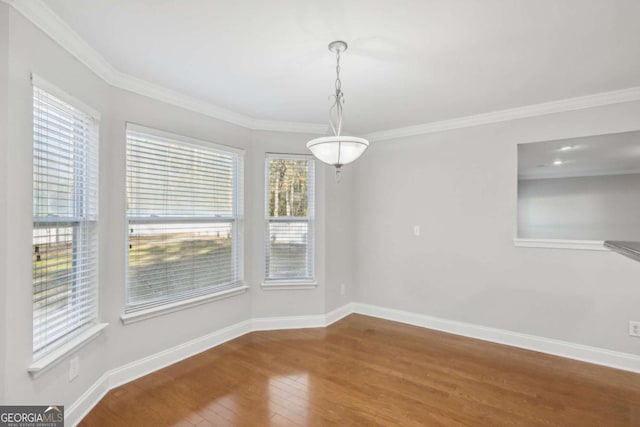 unfurnished dining area featuring wood-type flooring and crown molding