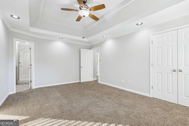 spare room with crown molding, ceiling fan, a raised ceiling, and carpet floors