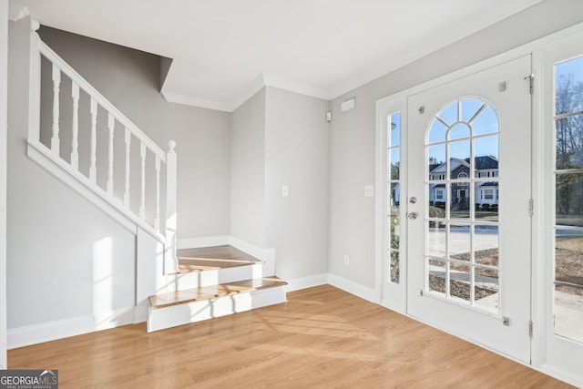 entrance foyer with crown molding and wood-type flooring