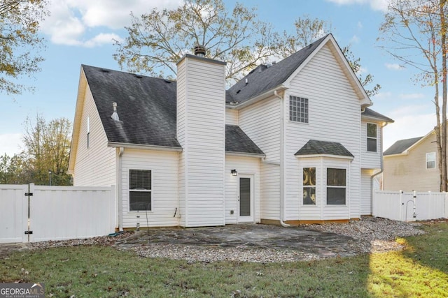 back of property with a yard and a patio area