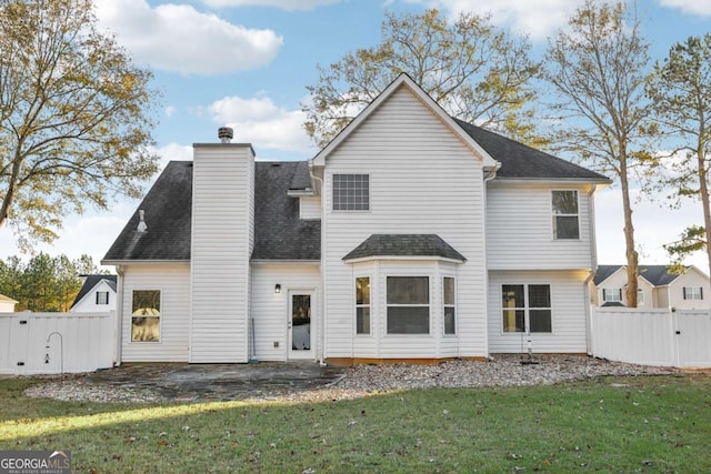 rear view of property with a lawn