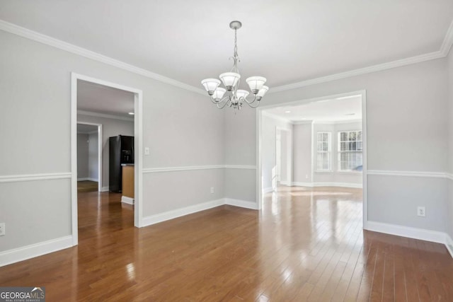 unfurnished room with crown molding, a notable chandelier, and dark hardwood / wood-style flooring