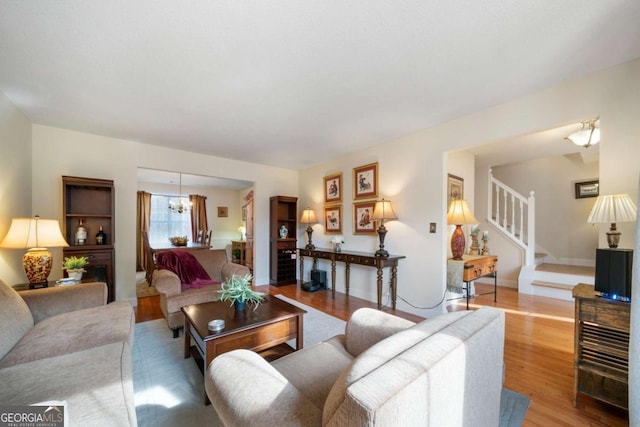 living room with a notable chandelier and light hardwood / wood-style floors