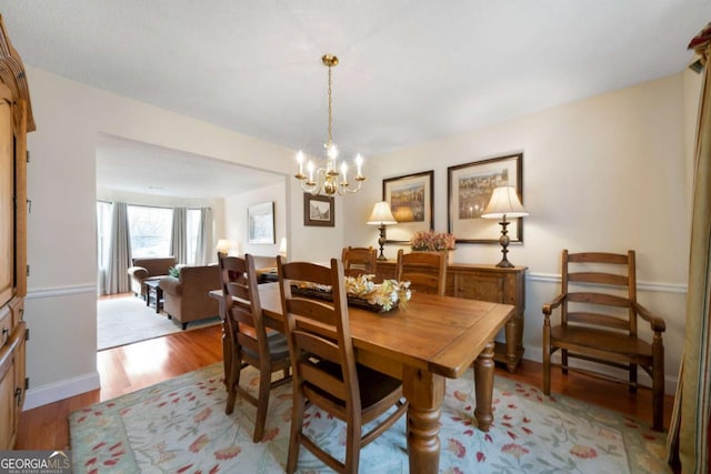 dining space featuring light hardwood / wood-style flooring and an inviting chandelier