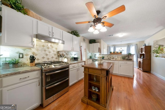 kitchen with white cabinetry, light hardwood / wood-style flooring, and double oven range