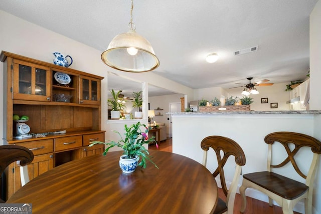 dining room with ceiling fan and a textured ceiling