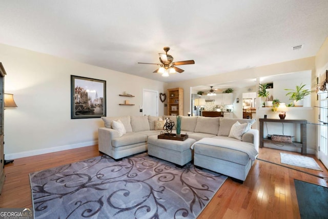 living room with ceiling fan and hardwood / wood-style flooring