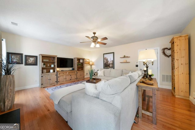 living room featuring ceiling fan and light hardwood / wood-style flooring