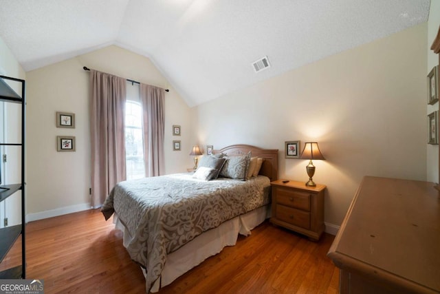 bedroom featuring wood-type flooring and lofted ceiling