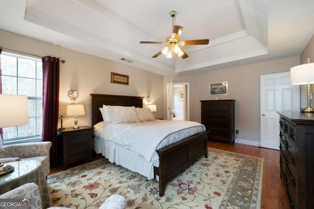 bedroom featuring a tray ceiling, ceiling fan, and light hardwood / wood-style floors