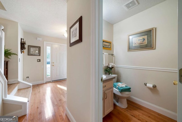 entryway featuring a textured ceiling and light hardwood / wood-style flooring