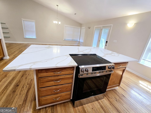 kitchen featuring pendant lighting, vaulted ceiling, stainless steel range with electric cooktop, and a center island