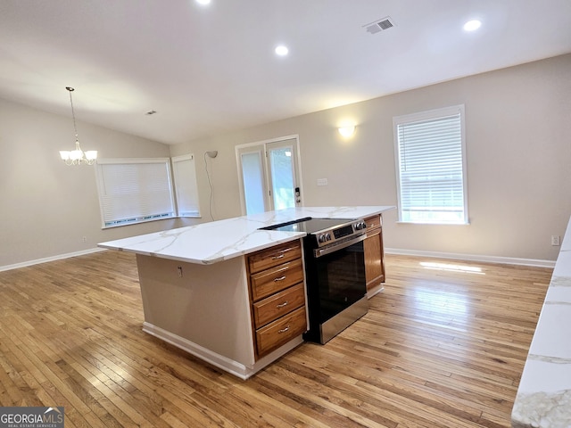 kitchen featuring stainless steel electric range, light hardwood / wood-style flooring, hanging light fixtures, light stone countertops, and a kitchen island