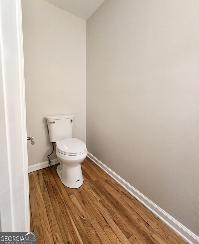 bathroom with hardwood / wood-style floors and toilet