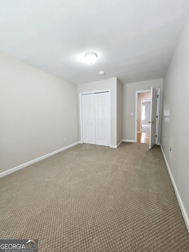 unfurnished bedroom with carpet floors and a closet