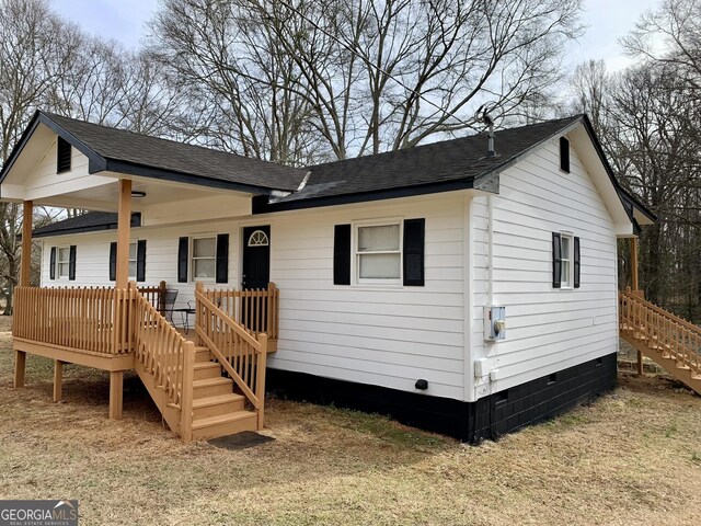 view of home's exterior with a lawn and a deck