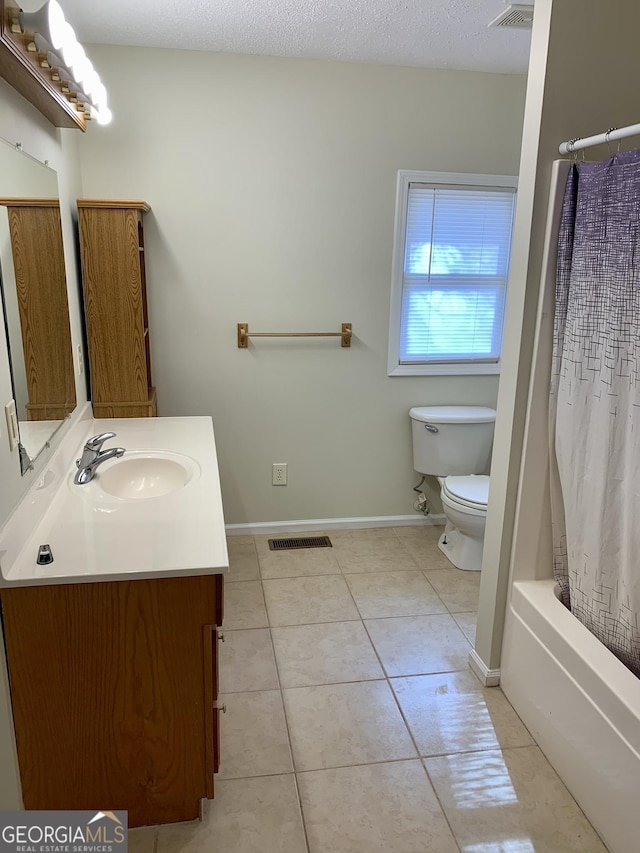 full bathroom featuring shower / bath combo, tile patterned flooring, vanity, a textured ceiling, and toilet