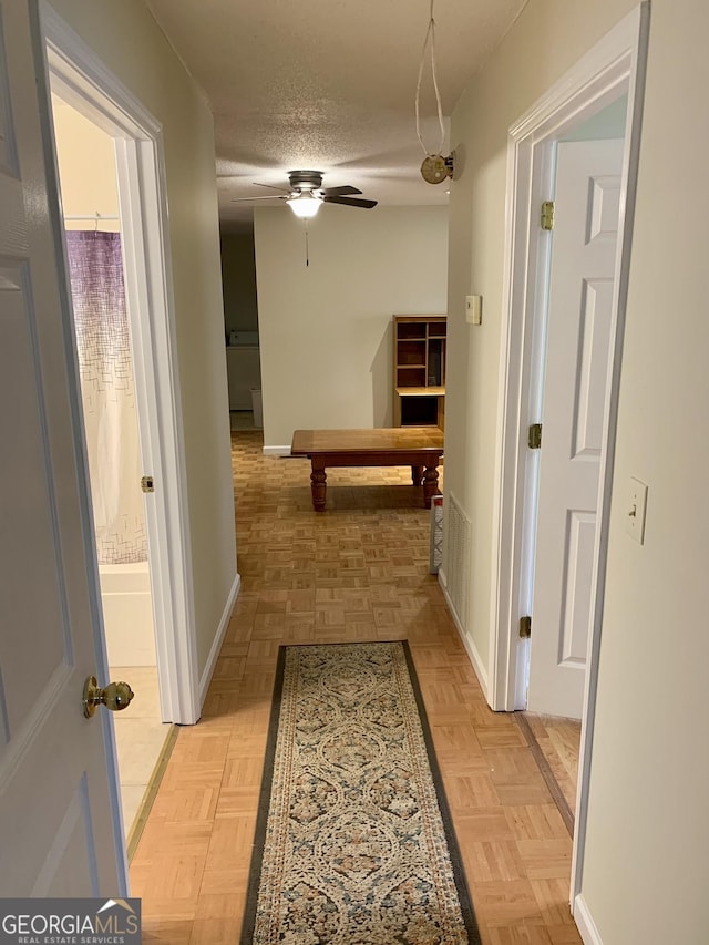 hall with a textured ceiling and light parquet floors