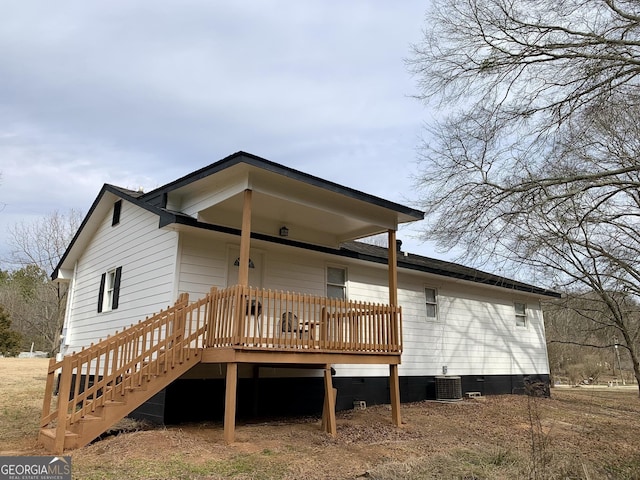 rear view of house with a wooden deck and central AC unit