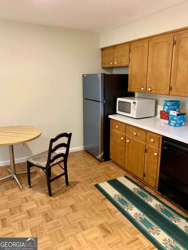 kitchen with dishwasher, stainless steel refrigerator, light parquet flooring, and a textured ceiling