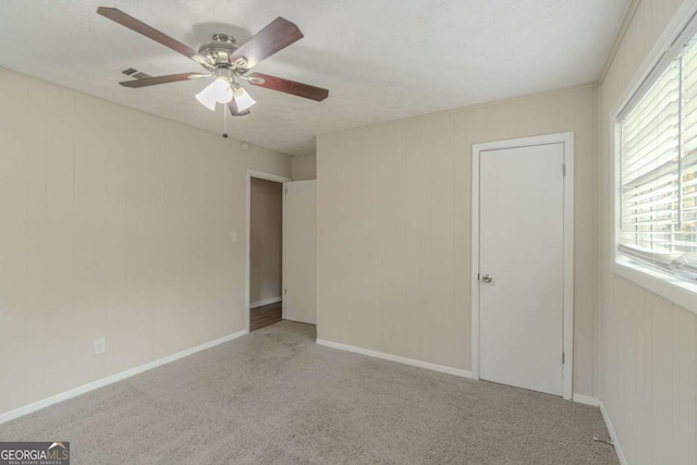 unfurnished room with carpet flooring and ceiling fan