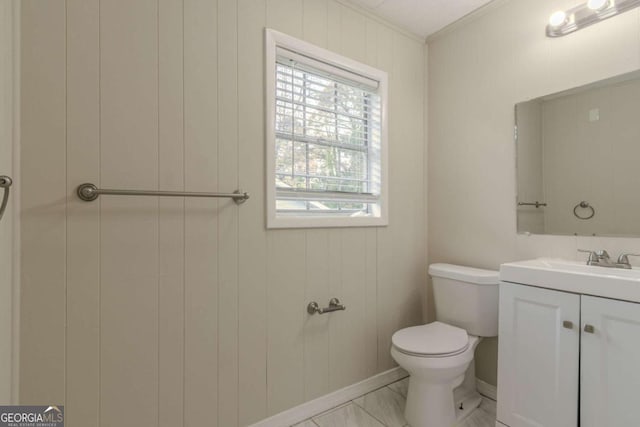 bathroom featuring vanity, wood walls, toilet, and crown molding