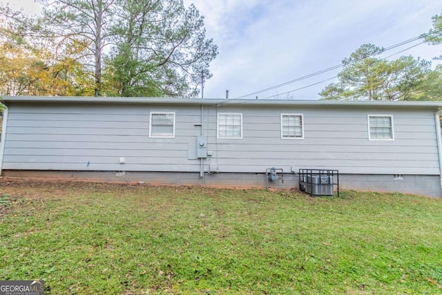 back of house featuring a yard and central AC unit