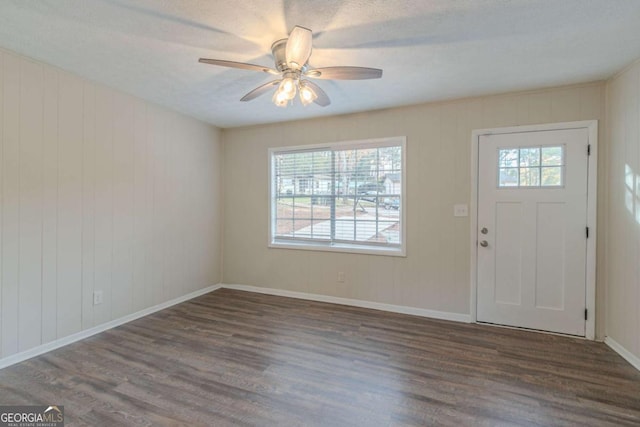 foyer entrance with a textured ceiling, a wealth of natural light, ceiling fan, and dark hardwood / wood-style floors