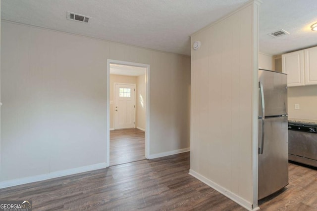 kitchen featuring white cabinets, wood-type flooring, a textured ceiling, and appliances with stainless steel finishes