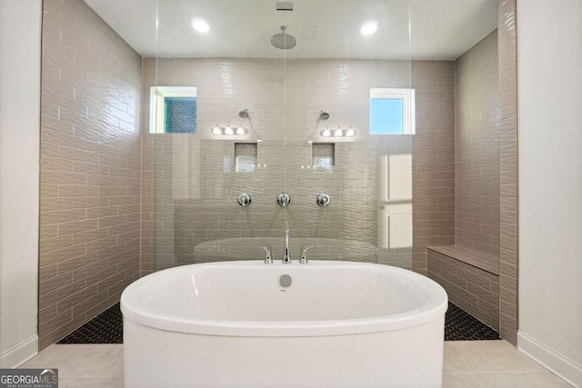 bathroom featuring tile patterned floors, plus walk in shower, and tile walls