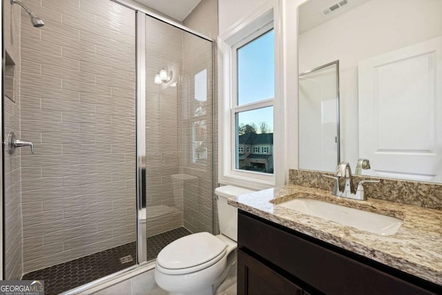 bathroom featuring walk in shower, vanity, and toilet