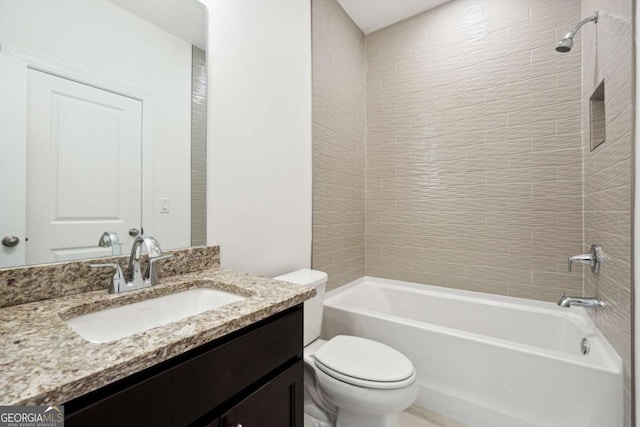 full bathroom featuring vanity, tiled shower / bath combo, and toilet