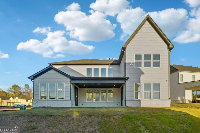 rear view of house featuring a lawn