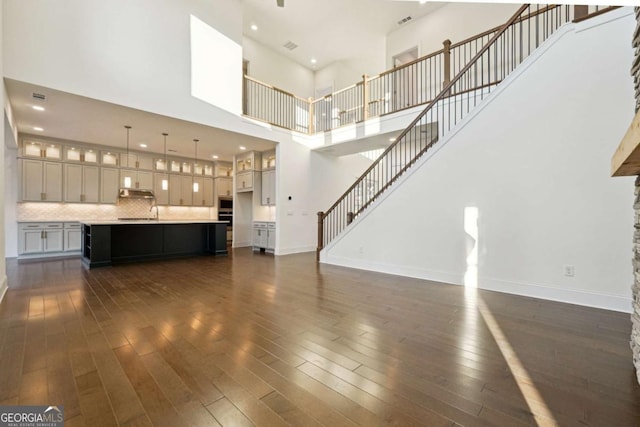 unfurnished living room featuring dark hardwood / wood-style flooring and a high ceiling