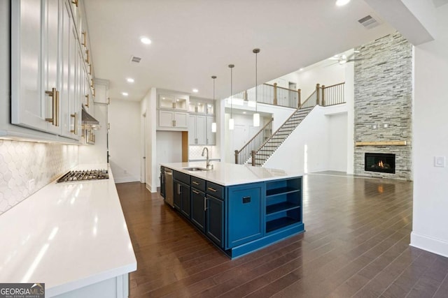 kitchen with backsplash, white cabinets, blue cabinets, dark hardwood / wood-style floors, and decorative light fixtures