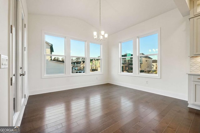 unfurnished dining area featuring dark hardwood / wood-style flooring, a healthy amount of sunlight, and a notable chandelier