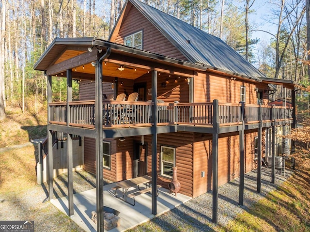 back of house featuring a deck and a patio