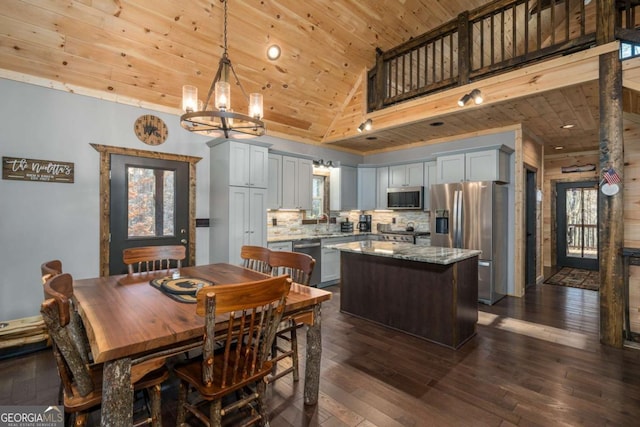 kitchen featuring dark wood-type flooring, a kitchen island, wood ceiling, and appliances with stainless steel finishes