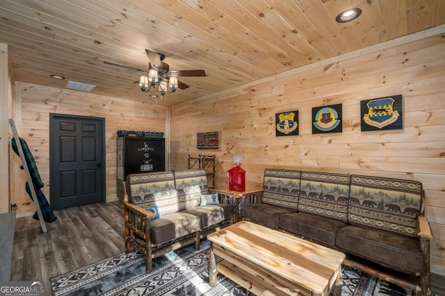 living room featuring ceiling fan, wood walls, wooden ceiling, and dark wood-type flooring