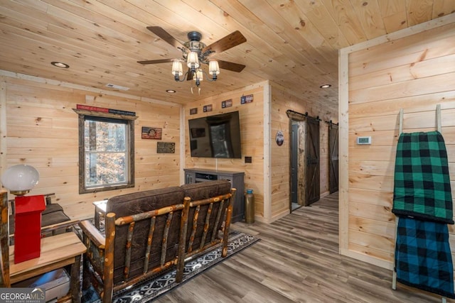 interior space with wooden walls, ceiling fan, wood-type flooring, and wooden ceiling