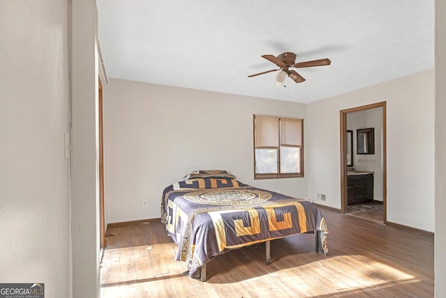 bedroom with ceiling fan, wood-type flooring, and ensuite bath