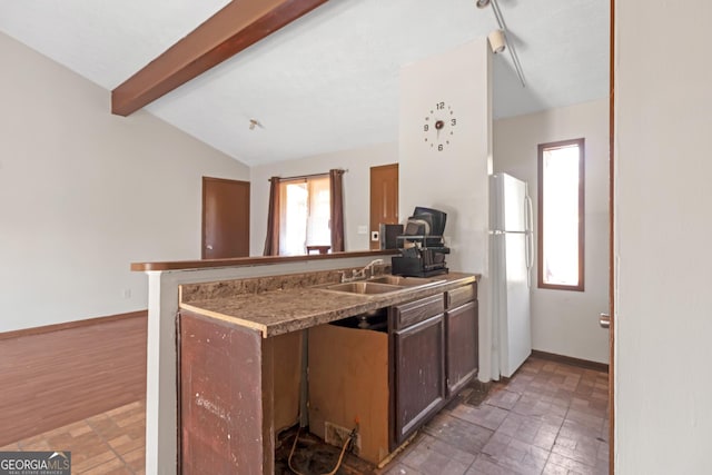 kitchen featuring sink, vaulted ceiling with beams, dark hardwood / wood-style floors, white refrigerator, and kitchen peninsula