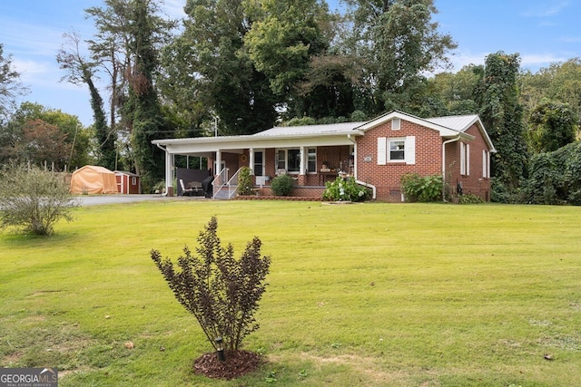 131 Logan Cir, Ellijay, GA 30540 - view of front of home featuring a front lawn, a storage unit, brick siding, and a porch