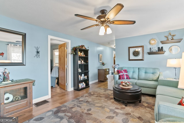 living room featuring hardwood / wood-style flooring and ceiling fan