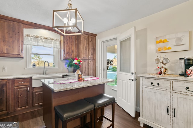 kitchen featuring dark hardwood / wood-style flooring, plenty of natural light, hanging light fixtures, and sink