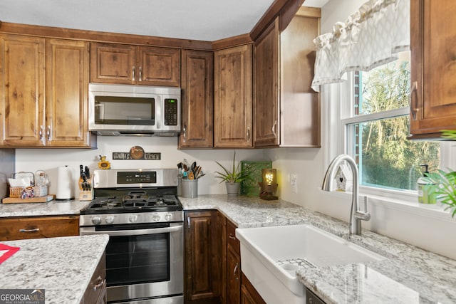 131 Logan Cir, Ellijay, GA 30540 - kitchen featuring appliances with stainless steel finishes, light stone countertops, and brown cabinets
