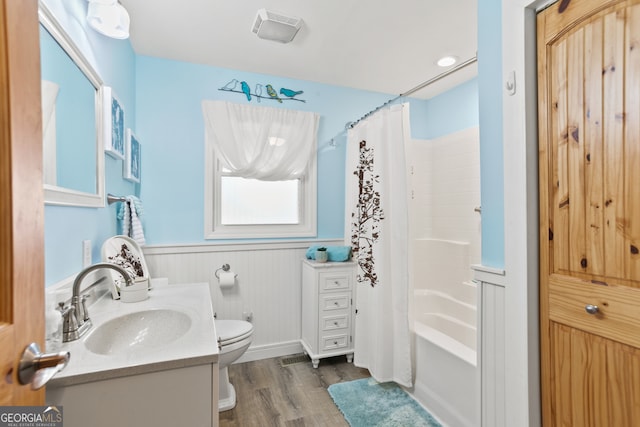 full bathroom with hardwood / wood-style flooring, vanity, toilet, and shower / tub combo