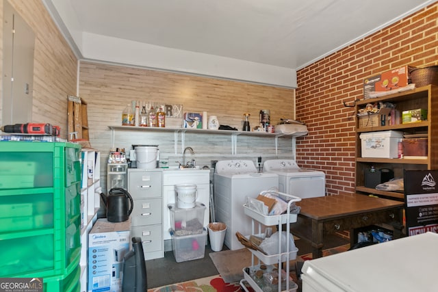 washroom featuring independent washer and dryer, sink, and brick wall