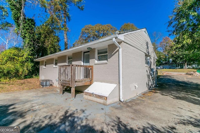 exterior space with a wooden deck and central AC unit