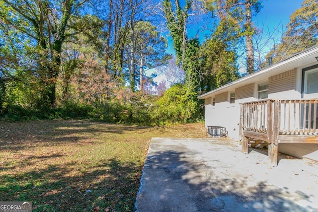 view of yard with a patio area and a wooden deck